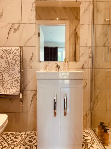 a bathroom with a sink and a mirror at A cozy apartment in Windsor