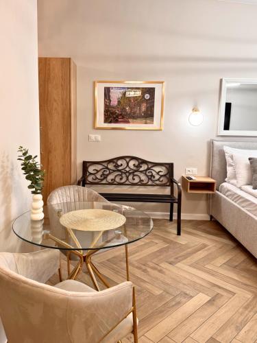 a living room with a couch and a glass table at ROOSEVELTA RESIDENCE Apartments - przy OFF Piotrkowska in Łódź