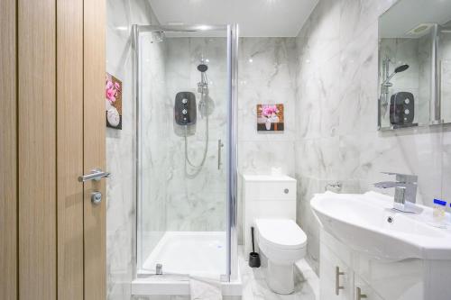 a bathroom with a shower and a toilet and a sink at -75ACR- Setup for your relaxed & amazing stay in Leeds