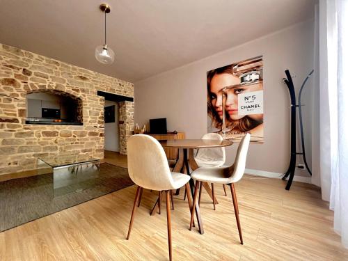 d'une salle à manger avec une table, des chaises et un mur en briques. dans l'établissement T2 refais à neuf, plein centre ville de Lorient, à Lorient