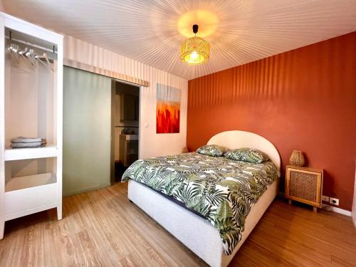 une chambre avec un lit et un mur rouge dans l'établissement T2 refais à neuf, plein centre ville de Lorient, à Lorient