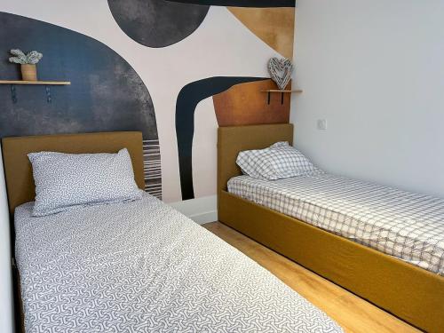 deux lits côte à côte dans une chambre dans l'établissement Appart 4pers RDC 2Chambres près Paris, Orly, Disney, à Saint-Pierre-du-Perray