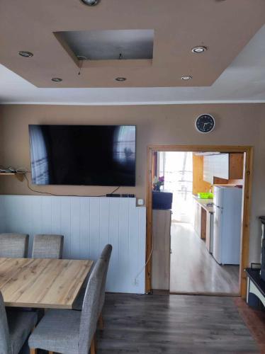 a dining room with a table and a television on the wall at Katica Vendégház in Siófok