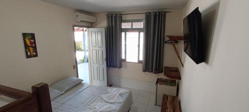a small bedroom with a bed and a window at Pousada da Ale in Ilhéus