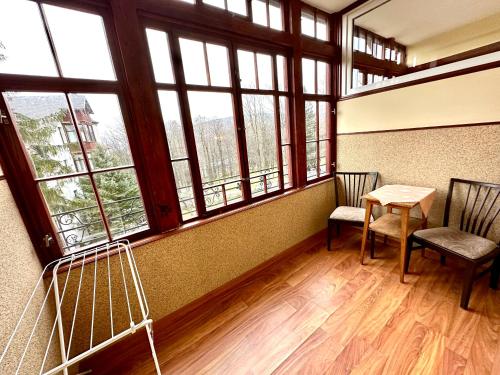 a room with two chairs and a table and windows at Kwatery Prywatne-Willa "Nadzieja" in Świeradów-Zdrój