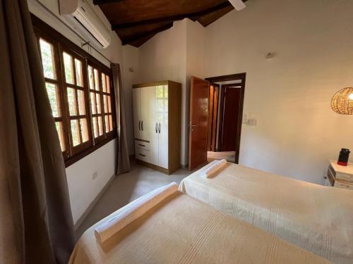 a bedroom with two beds and a window at San Bernardino,8vientos cabaña in San Bernardino