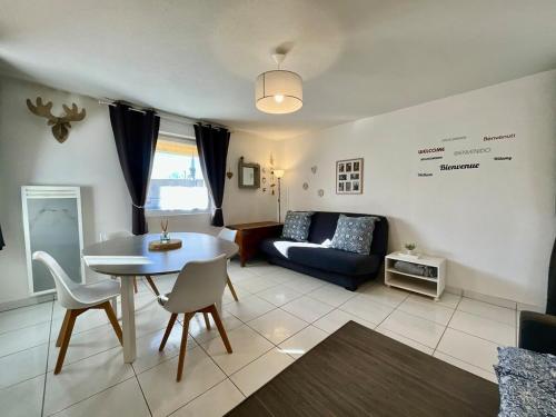 un salon avec une table et un canapé dans l'établissement Le Cosy Blanchepierre, bel appartement classé 3 étoiles, à Gérardmer