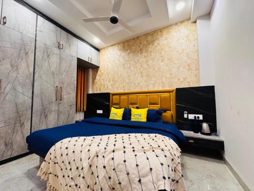 ein Schlafzimmer mit einem großen Bett mit blauen und gelben Kissen in der Unterkunft Home Escape 1BHK Elite Near Mahalaxmi Nagar in Indore