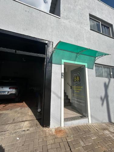 a door to a parking garage with a green awning at Pousada Route 58 in Gravataí