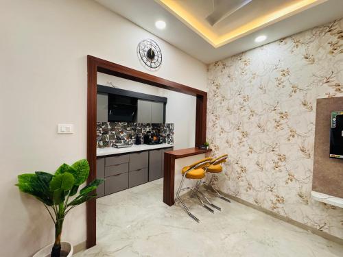 eine Küche mit einer Theke und Hockern in einem Zimmer in der Unterkunft Home Escape 1BHK Elite Near Mahalaxmi Nagar in Indore