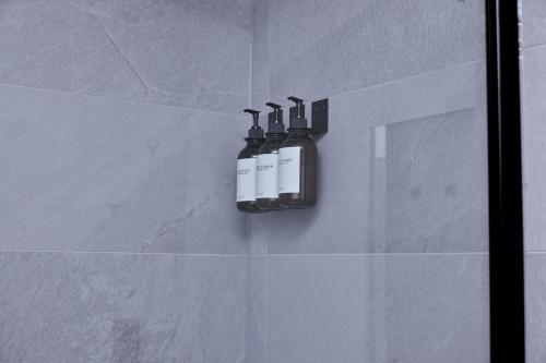 two bottles ofodorizers on the wall of a bathroom at Birmingham Gem 2-Bed with Netflix, Fun & Parking in Birmingham