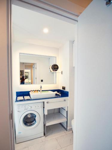 a bathroom with a washing machine and a sink at Luxury apartments in city center in Batumi