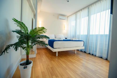 a bedroom with a bed and a potted plant at Luxury apartments in city center in Batumi