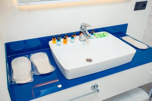 a bathroom with a white sink and some containers at Luxury apartments in city center in Batumi