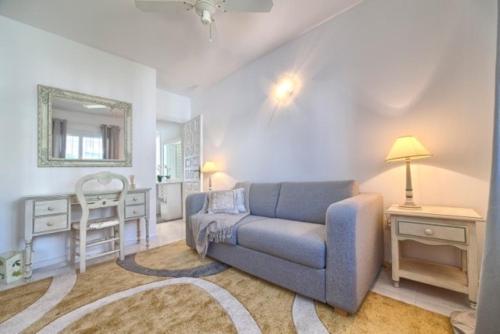 sala de estar con sofá azul y espejo en Appartement Pueblo Cortes del Golf, en Estepona