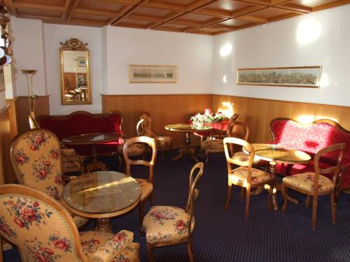 a waiting room with tables and chairs and a mirror at Hotel Bellevue - Traditional Swiss Hideaway in Wengen