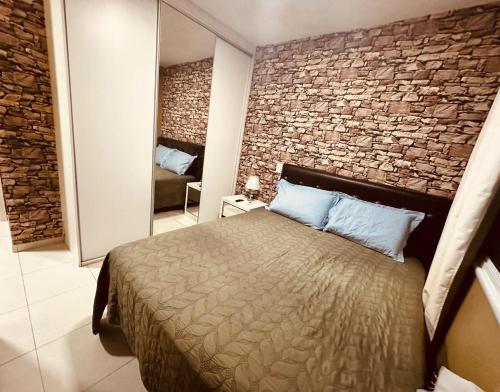 a bedroom with a bed and a brick wall at High Standard Apartment Cop 30 in Belém
