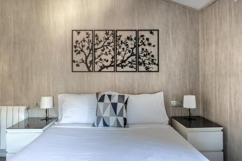 a bedroom with a white bed with two tables and two lamps at Villa Pepe Paz y Encanto Natural in Villarán