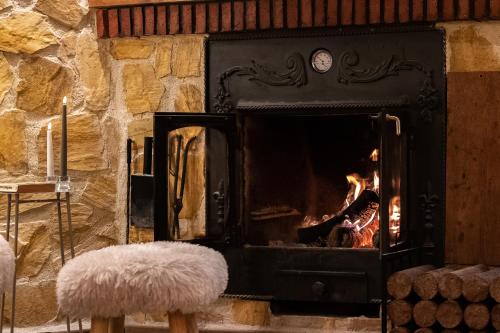 a fireplace with a fire in it with a white stool at Villa Pepe Paz y Encanto Natural in Villarán