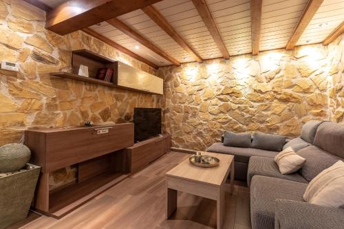 a living room with a stone wall at Villa Pepe Paz y Encanto Natural in Villarán
