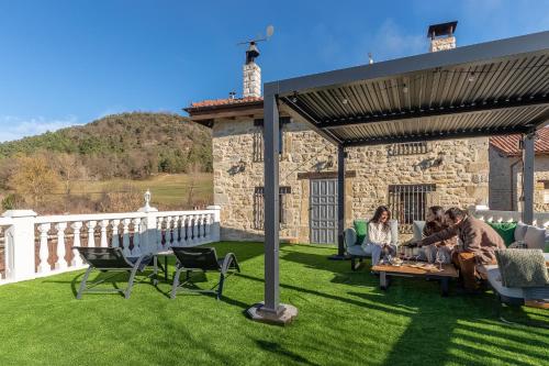 a group of people sitting on a table on a lawn at Villa Pepe Paz y Encanto Natural in Villarán