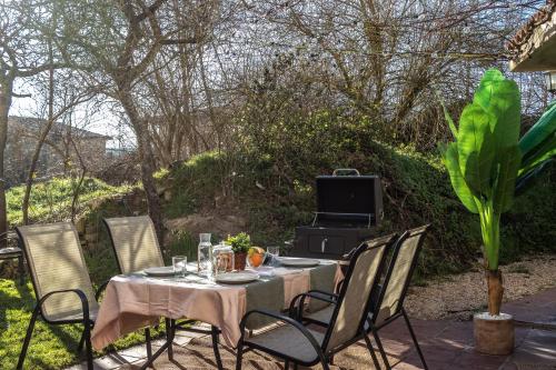 a table with chairs and a grill in a yard at Villa Pepe Paz y Encanto Natural in Villarán