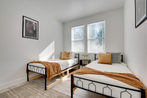 deux lits dans une chambre avec des murs et des fenêtres blancs dans l'établissement 3 Mi to Six Flags Atlanta Area Apartment, à Mableton