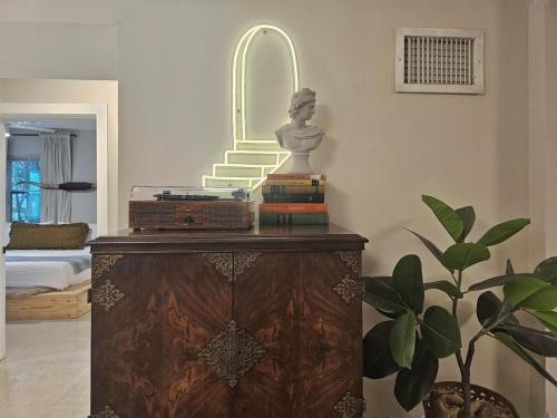 a room with a statue on a dresser with a mirror at -Disco Bungalow- One third mile to FTL Marine Center in Fort Lauderdale