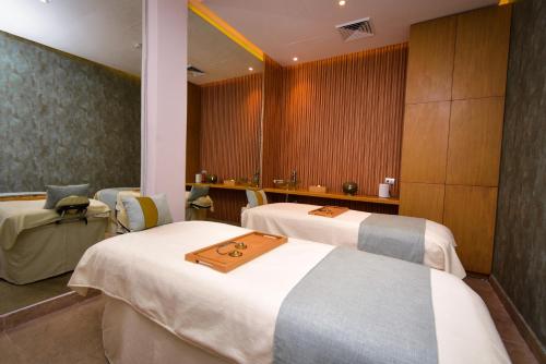 a room with three beds with a tray on them at Hotel NYX Cancun in Cancún