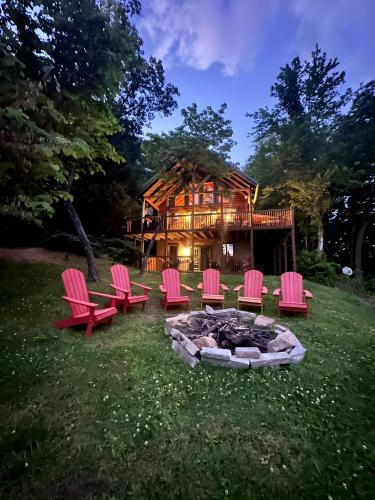 a group of chairs and a fire pit in front of a log cabin at Thistle Britches, Secluded Mountain Cabin with Stunning Mountain Views, 1 Acre Next to Dollywood, Hot Tub, Pet Friendly in Sevierville
