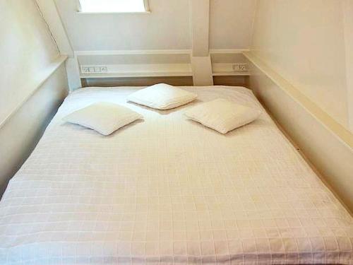 a bed in a small room with two pillows on it at 2 person holiday home in Bogense-By Traum in Bogense