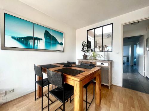 une salle à manger avec une table et des chaises en bois dans l'établissement Havre de paix au coeur de Larmor-Plage !, à Larmor-Plage