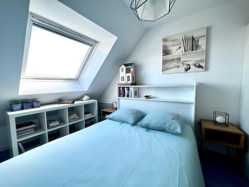 une chambre avec un lit blanc et une fenêtre dans l'établissement Havre de paix au coeur de Larmor-Plage !, à Larmor-Plage