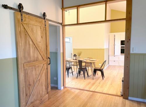 an open barn door in a living room with a table at Phillip Island Coastal Cabins in Sunderland Bay