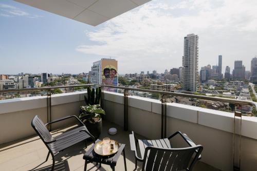 a balcony with a table and chairs and a city at Hotel Indigo Sydney Potts Point by IHG in Sydney