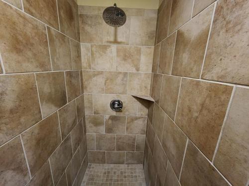 a bathroom with a shower with tiled walls and a shower at Lodge At Tellico in Tellico Plains