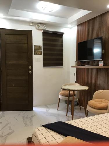 a room with a door and a tv and a table at Agateahs Place mini beach resort in Olongapo