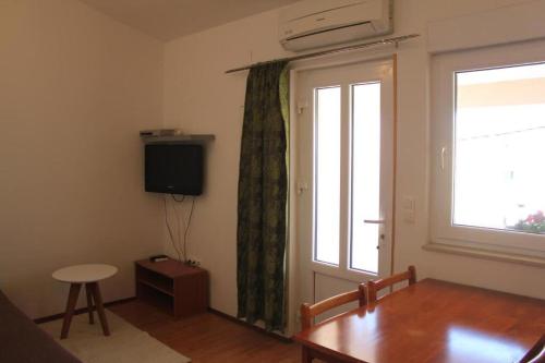 un soggiorno con un tavolo e una finestra di Apartments Ante a Posedarje (Possedaria)