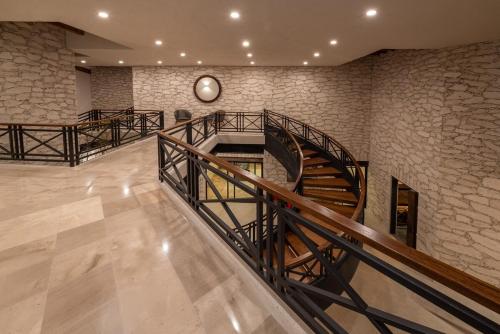 a staircase in a building with a clock on the wall at Quinta Don Luis in Querétaro