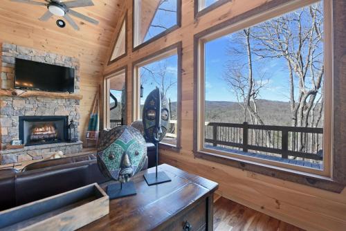 a living room with a fireplace and a large window at Stoneman Lodge | Cherry Log in Cherry Log