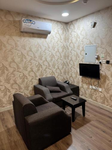 a living room with a couch and a air conditioner at Oroub El Forssan in Buraydah