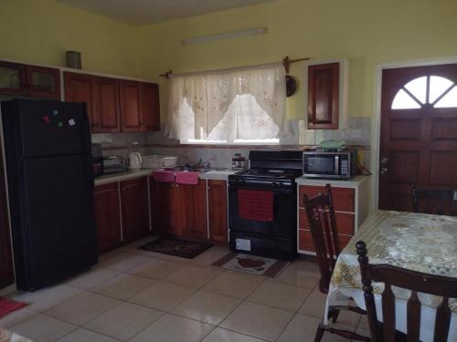 a kitchen with a black refrigerator and a table at Seaview Guesthouse Apt#1 in Bank Level
