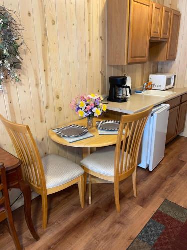 a kitchen with a table and two chairs and a table with flowers at Mountain Aire Cottages, Inn, & Glamping in Clayton
