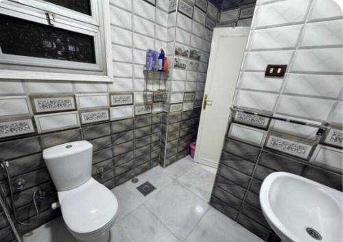 a bathroom with a toilet and a sink at The GEM Star House in Cairo