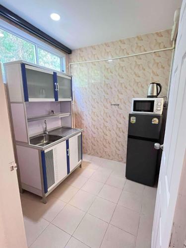 a small kitchen with a sink and a refrigerator at Elephant Sports Bar and Accommodation in Phuket