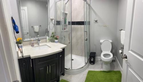 a bathroom with a shower and a sink and a toilet at F3 Spacious room with 2 queen beds and TV in Mississauga