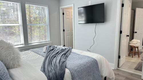 un soggiorno con letto e TV a parete di Modern new townhouse near Stone Mountain Sleeps 10 a Snellville