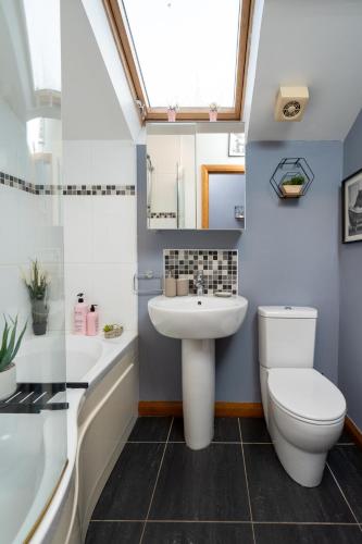 a bathroom with a white toilet and a sink at Luxury 5-Bed Penthouse with Free Parking & Views in Belfast