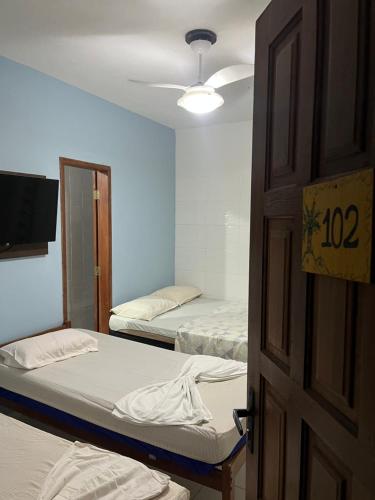 a room with two beds and a open door at Pousada encasa in São Mateus