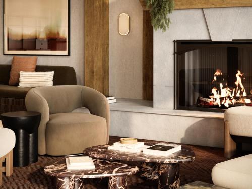 a living room with a fireplace and a chair at The Kenrick Hotel in Banff